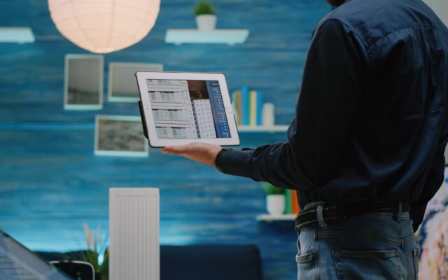 Close up of architect using tablet with touch screen to analyze building model for architectural development. Man engineer working with device for construction layout and design.
